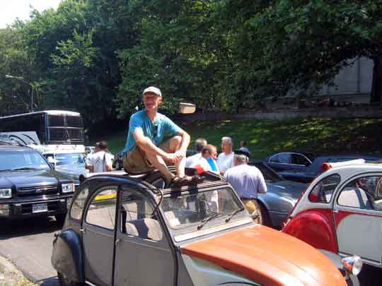 Photo d'un monsieur sur le toit d'une 2cv