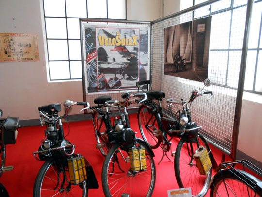 Un bel alignement de Vélosolex avec des bidons jaunes de Solexine