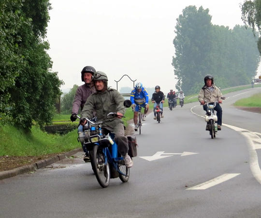 Un cycliste au milieu des Vélosolex